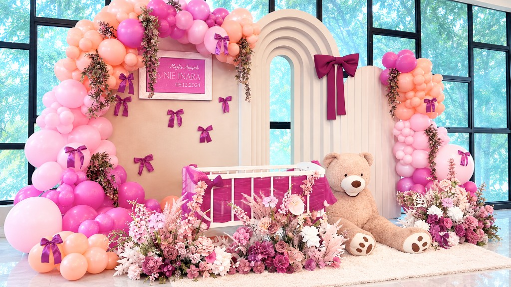 Pink Majlis Aqiqah styling with organic balloon garlands, a white cradle and a giant teddy, by Bella's Baskett.