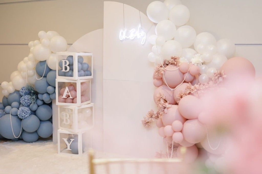 Oh Baby shower backdrop with dusty blue and blush balloon garlands, neon script and stacked BABY blocks.